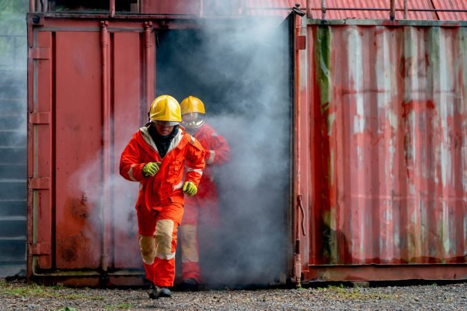 Two firefighter men run out from room cover with huge smoke after fire occur inside the building.
